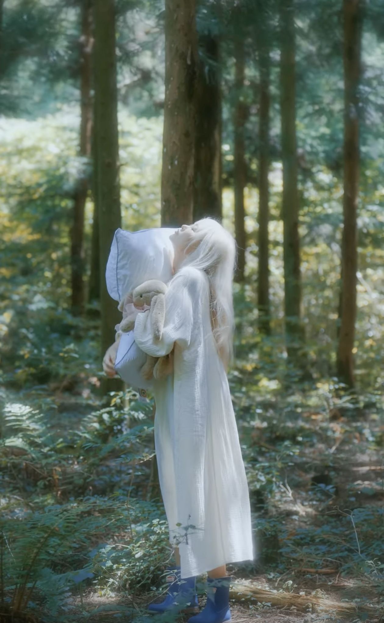 Girl in white nightgown walking in the forest